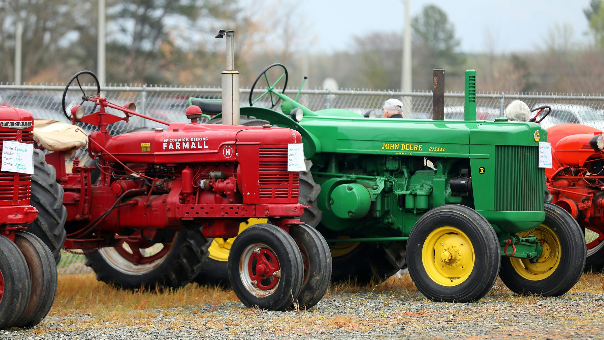 a row of red and green farm tractors
