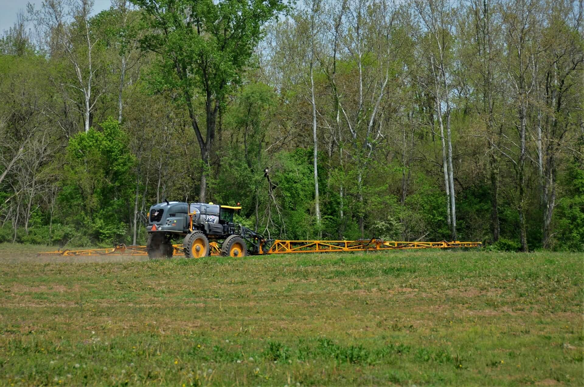 a tractor pulling a trailer behind it through a field